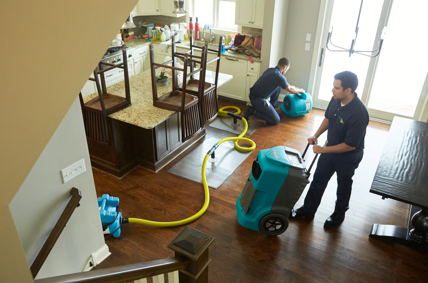 ServiceMaster By Simons technicians begin wood floor drying process after a water damage.